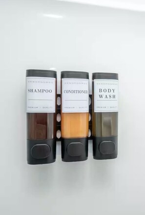 Three bottles of hair care products labeled shampoo, conditioner, and body wash.