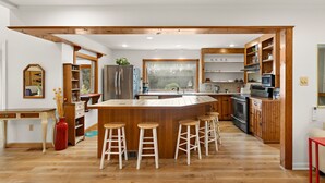 A spacious kitchen with a central island, wooden cabinets, and a large window. - Charming 2-bedroom house on 2 dog friendly landscaped acres in lovely Chester  (Chester)