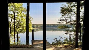 Näkymä järvelle, jossa laiturilta on yhteys betoniselle alustalle, ja kaikkialla ympärillä on puita.