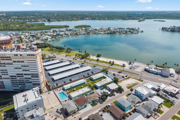 An aerial view of a coastal town with a marina, buildings, and a large body of water. - Beachfront Condo: Redington Shores Retreat! (Redington Shores)