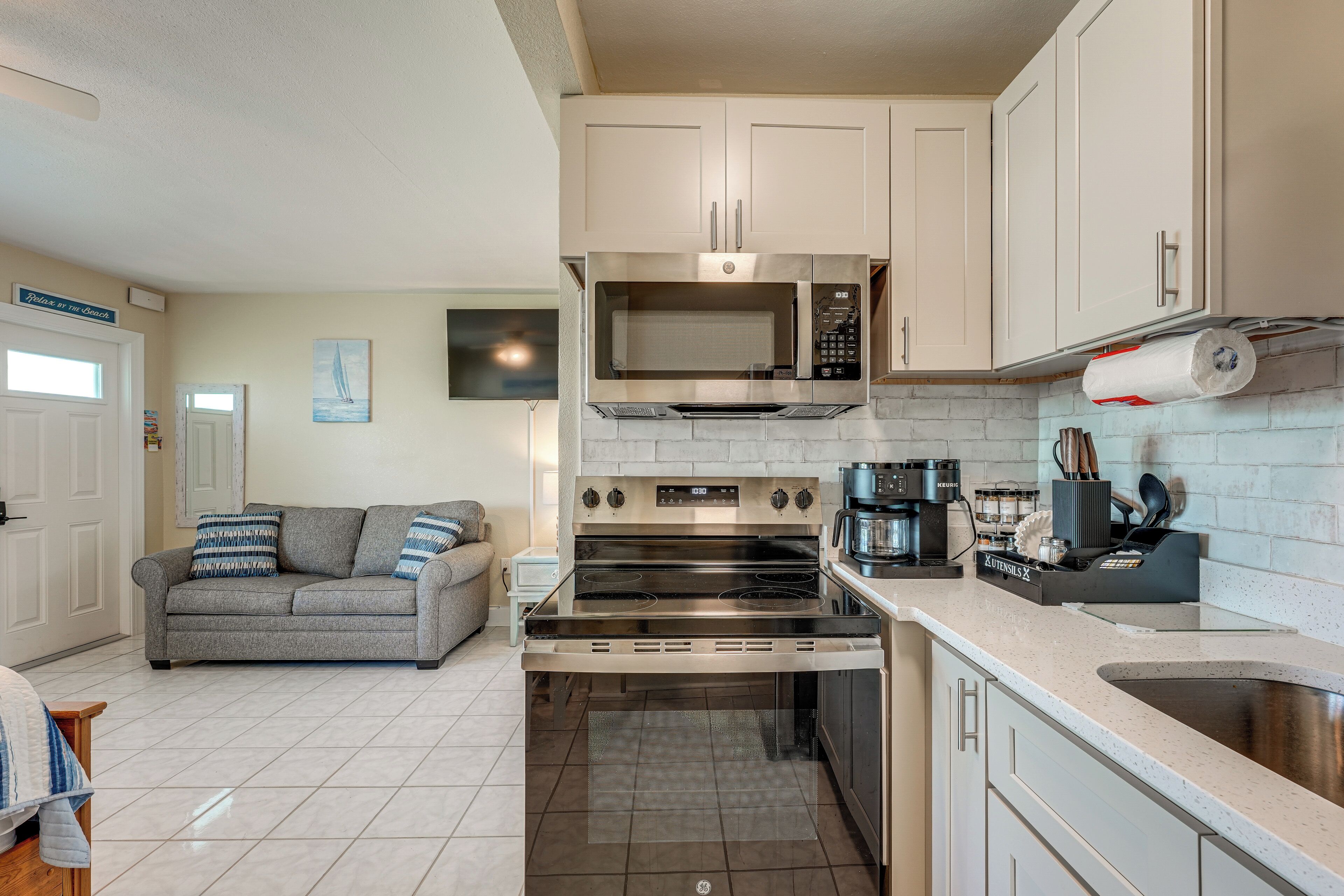 A compact kitchen with a built-in oven, microwave, and coffee maker.