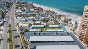An aerial view of a coastal city with a beach, buildings, and a parking lot. - Beachfront Condo: Redington Shores Retreat! (Redington Shores)