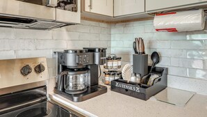 A kitchen with a coffee maker, cabinets, and a utensil holder. - Beachfront Condo: Redington Shores Retreat! (Redington Shores)