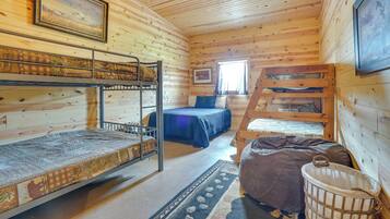A cabin with bunk beds, a bed, a window, and a ceiling fan.