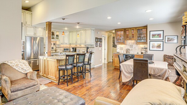 A spacious kitchen with wooden cabinets, a central island, and a dining area with a table and chairs. - Golf Course & Mtn Views: Avon Gem w/ Gas Grill! (Avon)