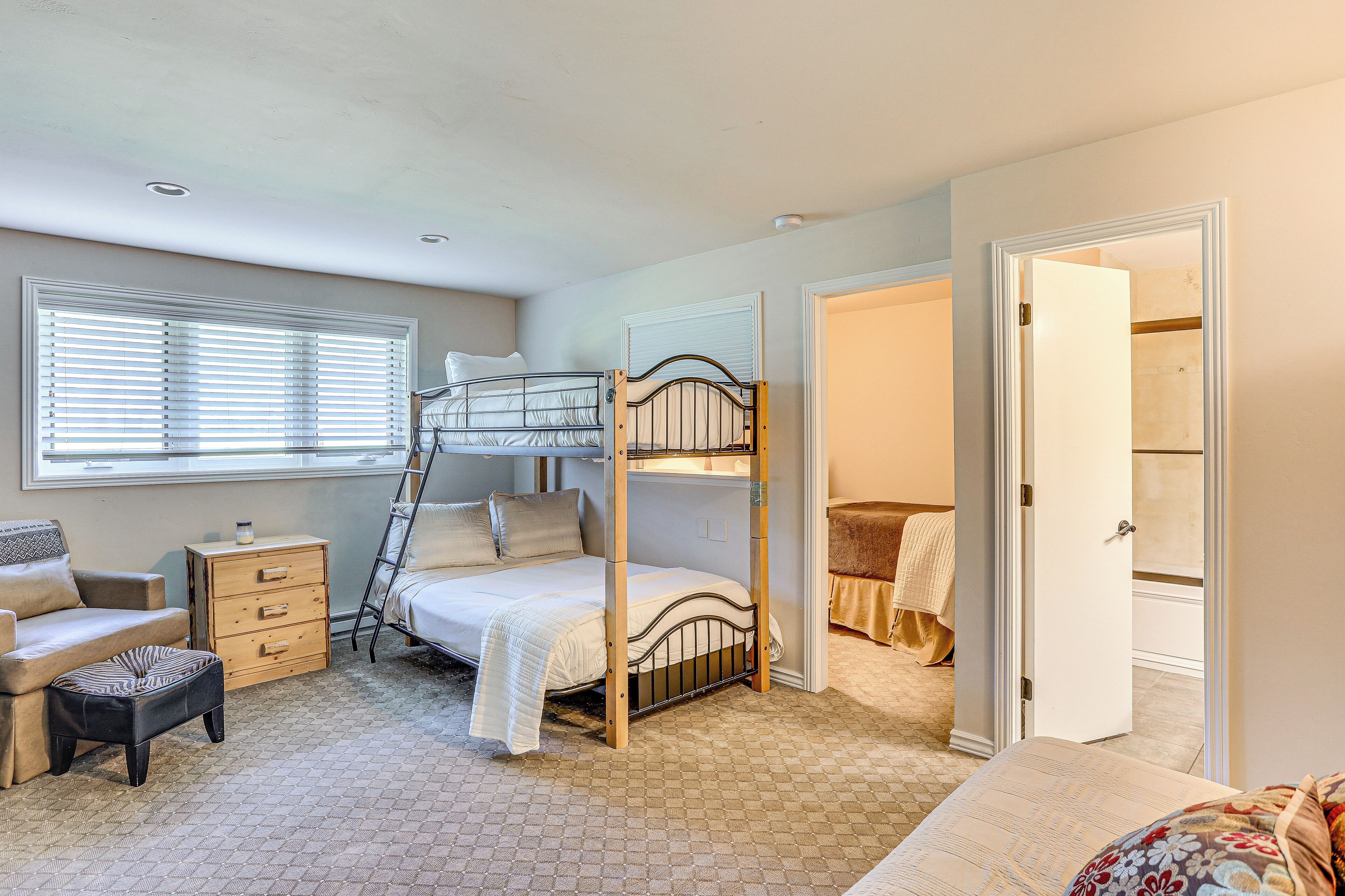 Een slaapkamer met stapelbedden, een dressoir, een stoel en een kledingkast.