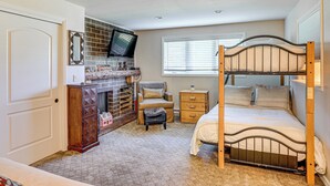A bedroom with a bunk bed, a dresser, a chair, a television, and a fireplace. - Golf Course & Mtn Views: Avon Gem w/ Gas Grill! (Avon)