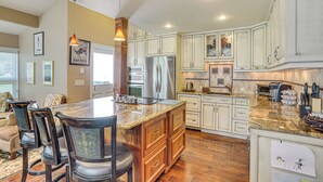 A spacious kitchen with a central island, wooden cabinets, and stainless steel appliances. - Golf Course & Mtn Views: Avon Gem w/ Gas Grill! (Avon)