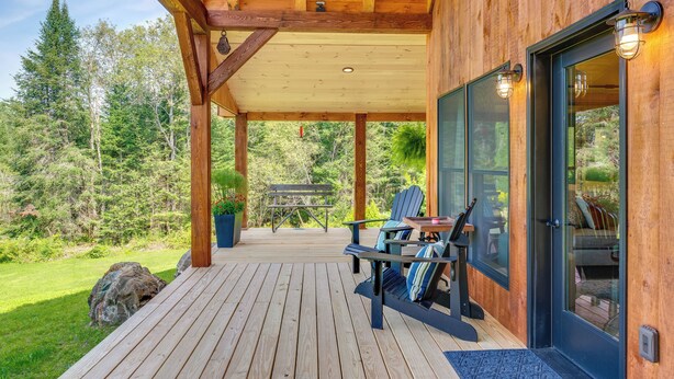 A wooden deck with outdoor seating, a glass door, and a view of a forested area. - 'sunset House' Greensboro Forest Escape & Fire Pit (Stannard)