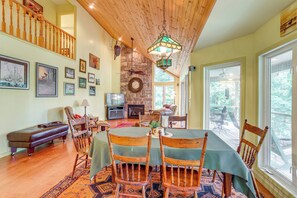A dining area with a wooden table, chairs, and a fireplace.