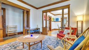 Amplia sala de estar con una mesa de centro de madera, un sofá rojo y un tapete azul con estampado.
