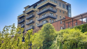 Un edificio de varios pisos con balcones, fachada de ladrillo y cielo despejado.