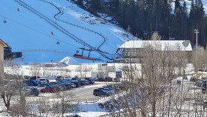 A ski resort parking lot with a ski lift in the background.