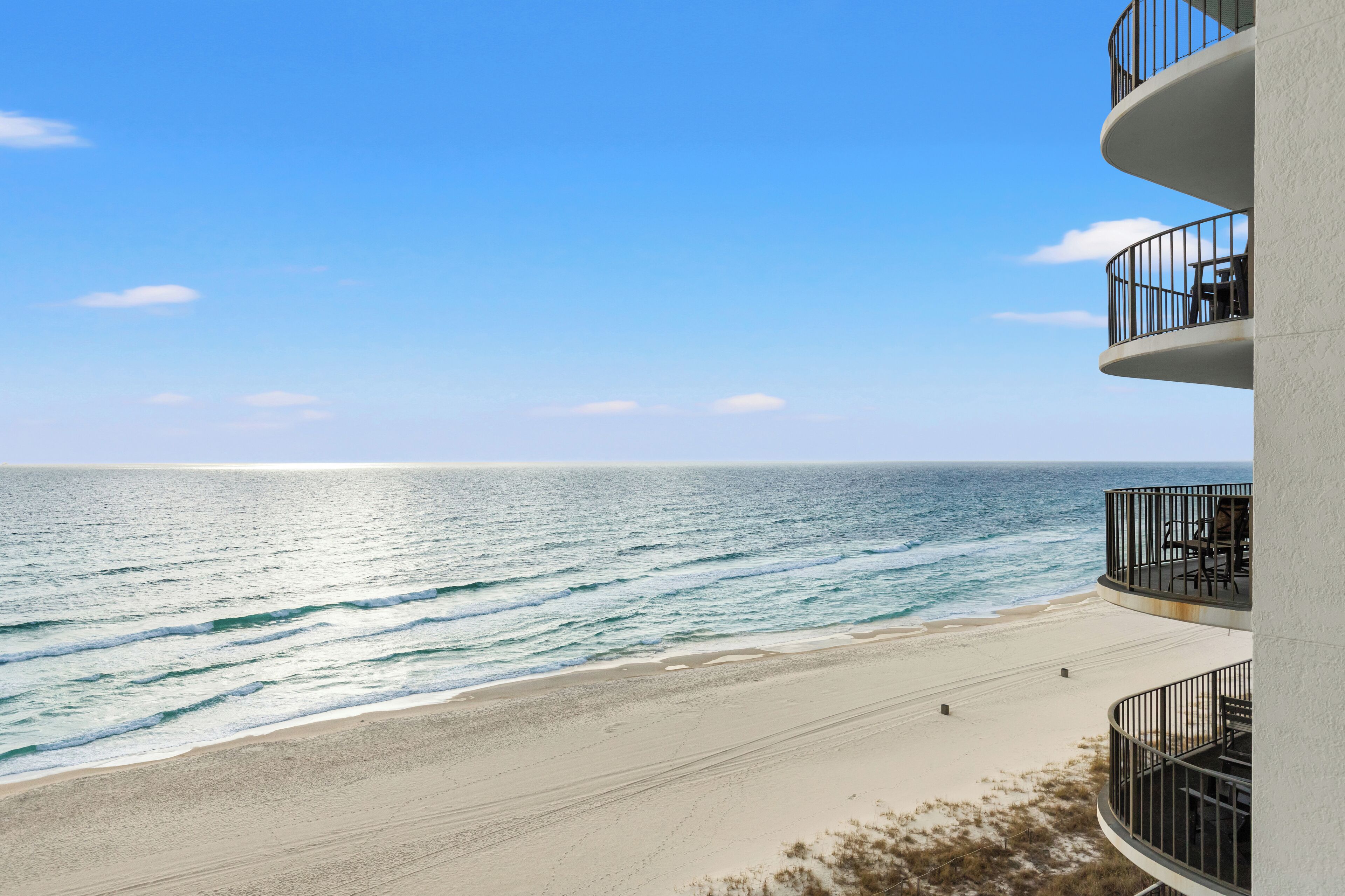 Et hotel ved stranden med balkon med udsigt over havet.