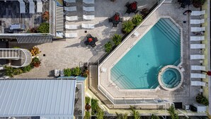 Luchtbeeld van een hotel met een zwembad, ligbedden en een overdekt terras.