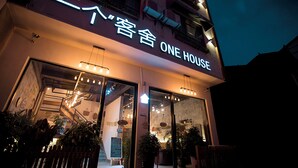 En bygning med et skilt, der står "ONE HOUSE", og en trappe op til indgangen.