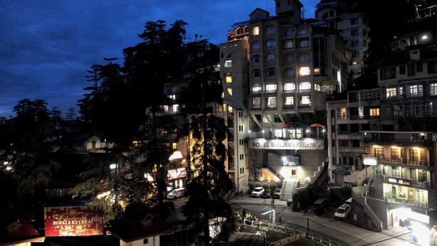 A multi-story hotel with a prominent entrance and signage for "Hotel El Baljees Regency." - Hotel Hans (Shimla)