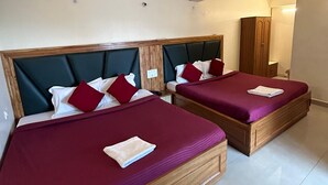 Two twin beds with wooden frames and green headboards, red bedding, and a wooden wardrobe in the background. - Hotel Hans (Shimla)
