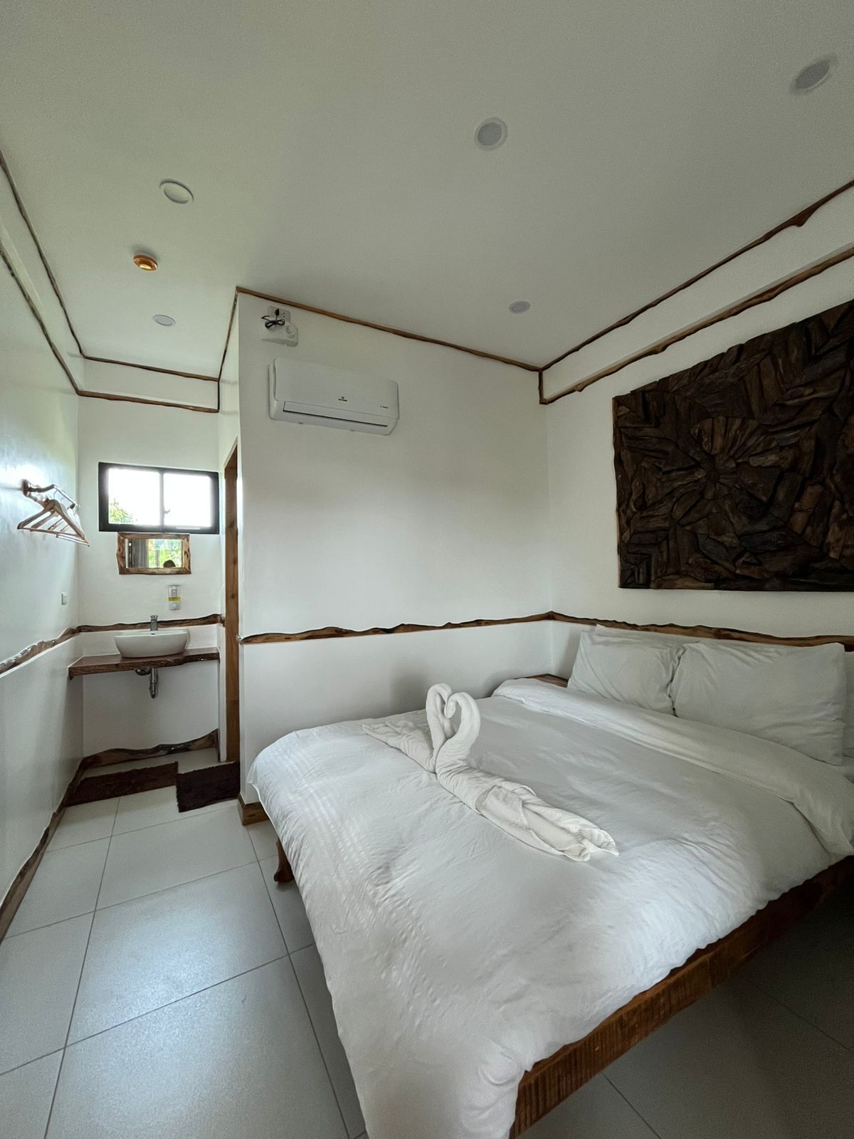 Une chambre d’hôtel avec un lit, un lavabo et une fenêtre.