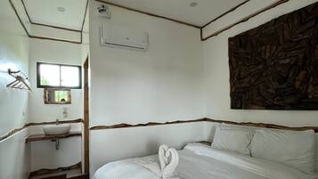 Une chambre d’hôtel avec un lit, un lavabo et une fenêtre.