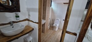 Slaapzaal | Badkamer | Een douche, een bidet, handdoeken, zeep