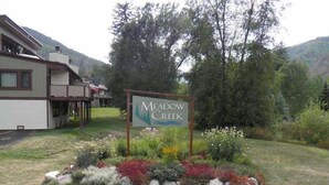 A sign for Meadow Creek with a landscaped garden in front. - 3-Bedroom Meadow Creek Townhom 3 Townhouse (Vail)