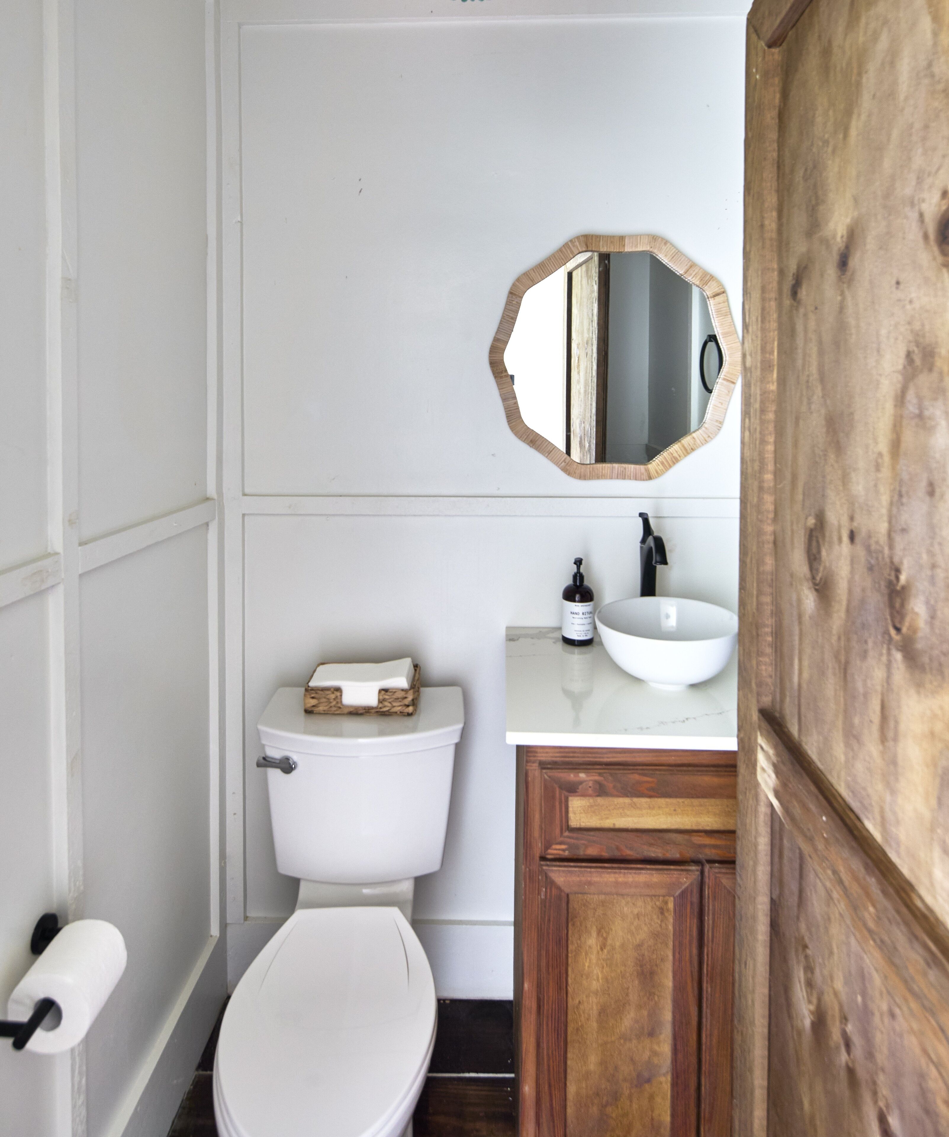 A bathroom with a toilet, a sink, and a mirror.