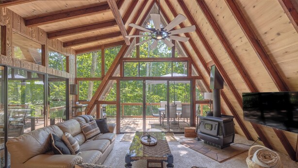 An attic-style living room with a large window, a fireplace, and a television.