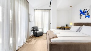 A hotel room with a bed, a chair, a desk, and a painting on the wall. - Charming Villa Vallis with swimming pool, jacuzzi and sauna (Kadumi)