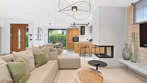 A modern living room with a sofa, a coffee table, and a fireplace. - Charming Villa Vallis with swimming pool, jacuzzi and sauna (Kadumi)