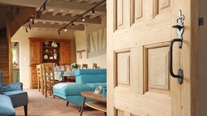 Un salón acogedor con un sofá azul, armarios de madera y suelo de baldosas.