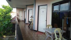 Un pasillo con puertas numeradas 10 y 11, una mesa con sillas y una ventana con vistas al follaje.
