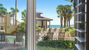 Un espace aménagé au bord de la piscine, avec des chaises longues, une piscine et une vue sur l’océan.