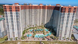Un hôtel de grande hauteur, avec de nombreux étages, une cour intérieure dotée d’une piscine et une vue sur l’océan.