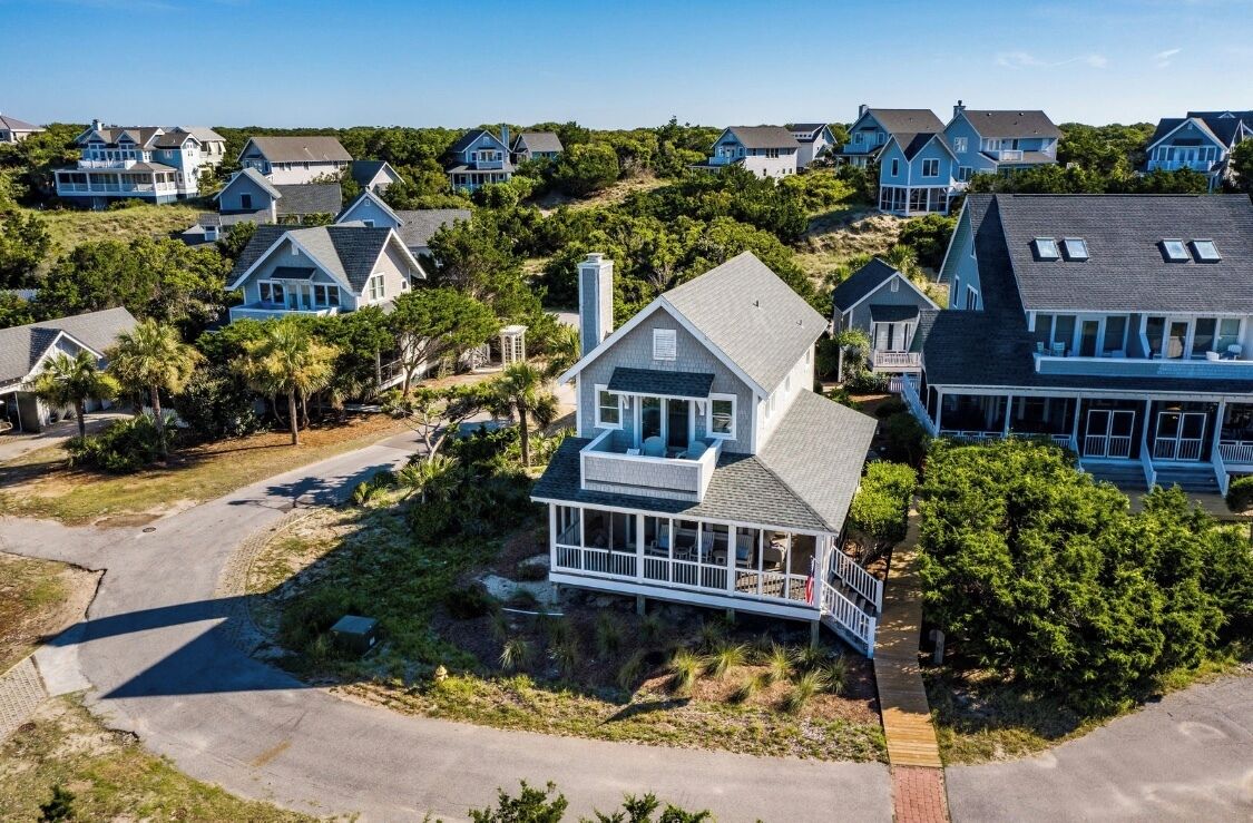 A coastal residential area with houses featuring gabled roofs and white exteriors.