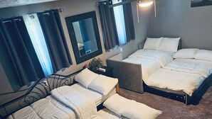 A hotel room with two beds, a small table, and a mirror. - City Living—sleeps 12 
15-20 mins from Acrisure Stadium, PNC Park, Mt Washington (Pittsburgh)