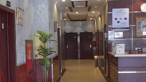 A hotel lobby with a polished tile floor, a reception desk, and a potted plant. - luluh elthurayaa (Riyadh)
