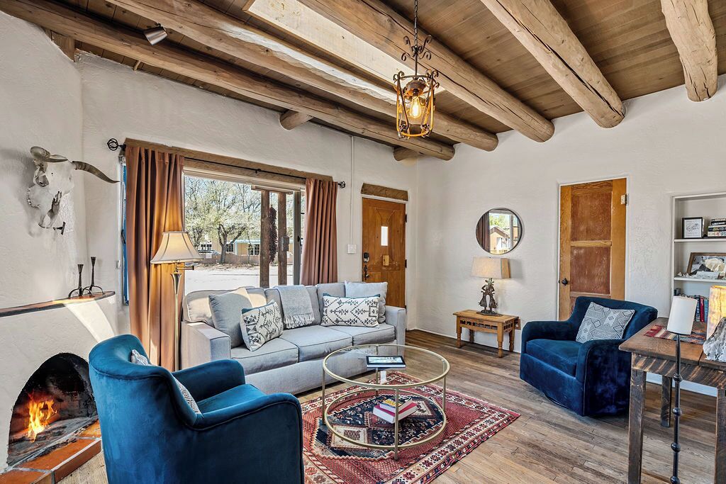 A living room with a fireplace, a sofa, a coffee table, and a blue armchair.