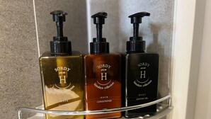 Tres botellas de acondicionador para cabello de la colección Sordy Himalayan sobre un estante de baño.