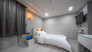 A modern hotel room with a bed, bedside table, TV, and a small desk. - Hotel Regen (Seoul)