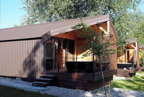 Enjoy the expansive views from the large windows and balcony of this cabin-style building.