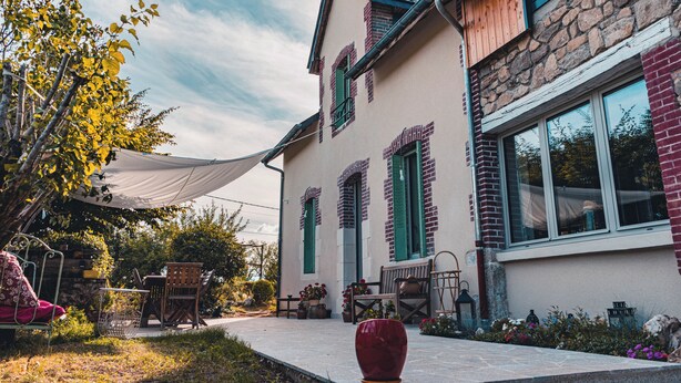 A two-story house with a stone facade, green shutters, and a large window. - Les jardins de Nanine (Lapleau)