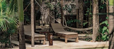 Een buitenzwembad, parasols bij het zwembad en ligstoelen