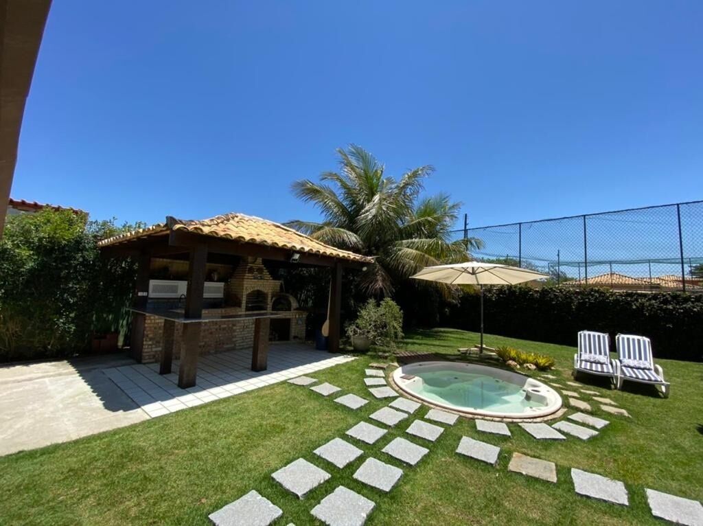 Un pati amb zona de barbacoa, piscina i dues gandules.