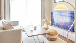 A modern living room with a sofa, a coffee table, a TV, and a lamp. - It' ta de ChouChou - Self Check-In Only (Osaka)