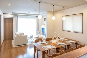 Un espace repas moderne avec une table en bois, dressée pour quatre personnes, entourée de chaises en bois.