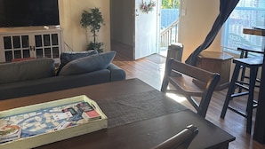 A dining area with a table and chairs, a television on a cabinet, and a ceiling fan. - 3-bedroom Mobile Home in enchanting Thunderbolt with WiFi, AC (Thunderbolt)