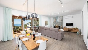 Una sala de estar moderna con sofá, mesa de comedor y televisor.