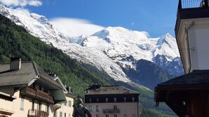 A mountain with snow-covered peaks, a building with balconies, and a clear blue sky. - Spacious T2 in the heart of Chamonix (Chamonix-Mont-Blanc)