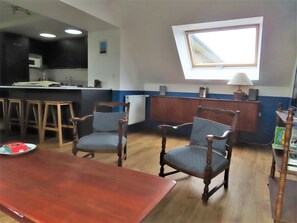 Cozy living space with a kitchen and dining area, featuring a modern stove, microwave, and wooden dining table.